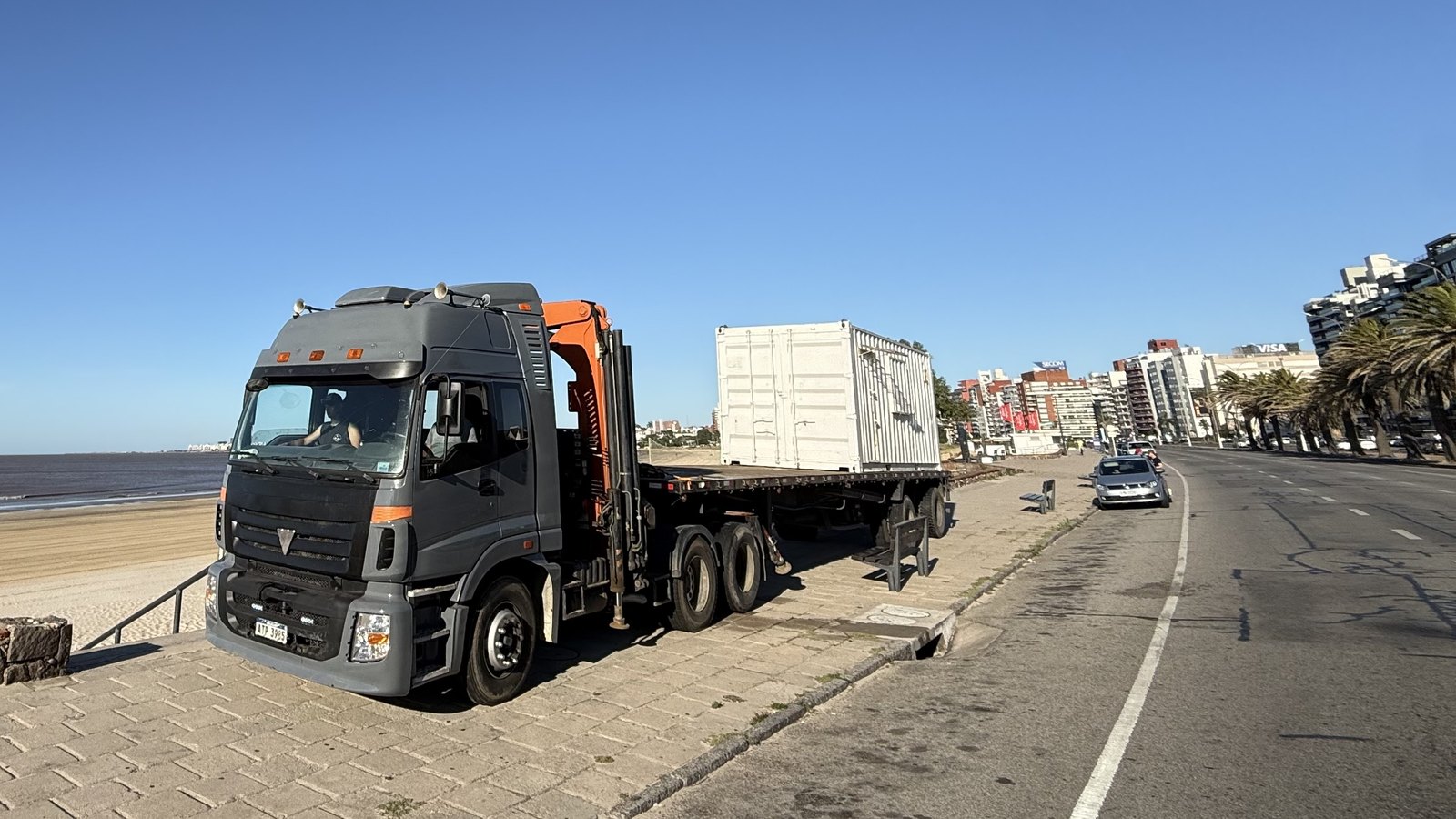 Camión grúa transportando un módulo por la rambla